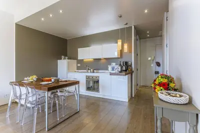 a kitchen with white cabinets and a table and chairs at MY CASA - FLEURS 22 - City Center - Modern w Terrace in Nice