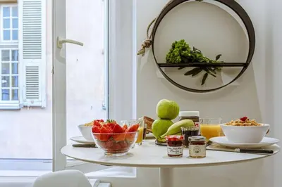 a table with a bowl of fruit and a mirror at MY CASA - BUNICO 1 - Old Town Renovated Studio in Nice