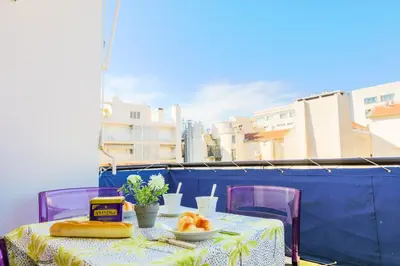 a table with a plate of food on a balcony at MASSENET PIETONNE AP4196 by Riviera Holiday Homes in Nice