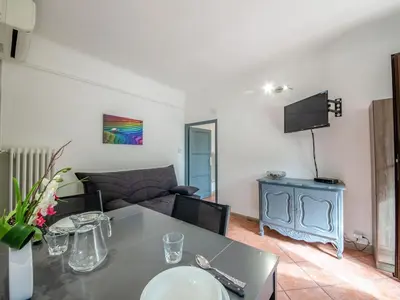 a living room with a table and a couch at Apartment Le Narcisse by Interhome in Cagnes-sur-Mer