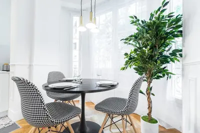 a dining room with a table and chairs and a potted plant at HEROLD Balcon in Nice