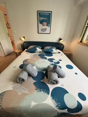 a bedroom with a bed with blue pillows on it at LE CLIO CARRÉ D'OR BEACH APARTMENT in Nice