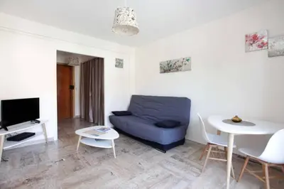 a living room with a blue couch and a table at Studio à Nice ensoleillé proche centre et plage in Nice