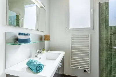 a white bathroom with a sink and a mirror at MY CASA - BERLIOZ 1 - City Center 2 rooms - Balcony in Nice