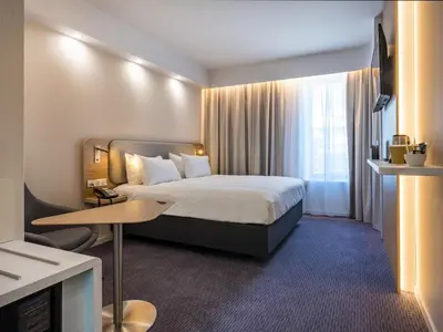a hotel room with a bed and a table at Holiday Inn Express - Nice - Grand Arenas by IHG in Nice