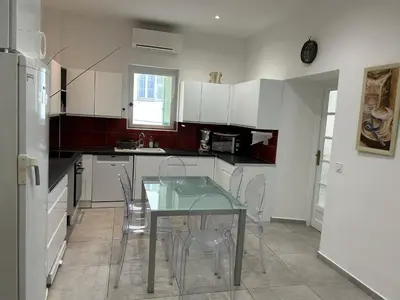 a kitchen with a glass table and white cabinets at Appart hyper centre Nice in Nice