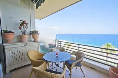 a table and chairs on a balcony with the ocean at BEACHSIDE SUITE PANORAMIC - PROMENADE HOLIDAY in Nice