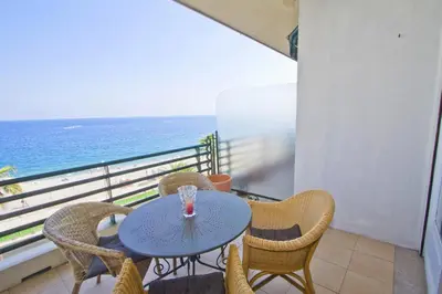 a table and chairs on a balcony with the ocean at BEACHSIDE SUITE PANORAMIC - PROMENADE HOLIDAY in Nice