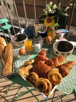 a table with a tray of bread and pastries on it at Beau 3 pièces, 7 pers, 2 terrasses, centre, calme, sécurité in Nice
