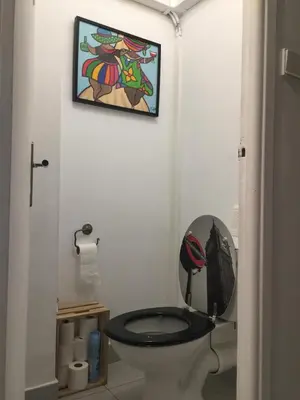 a bathroom with a toilet with a picture on the wall at Appartement T3 Climatisé entre mer et centre Nice in Nice