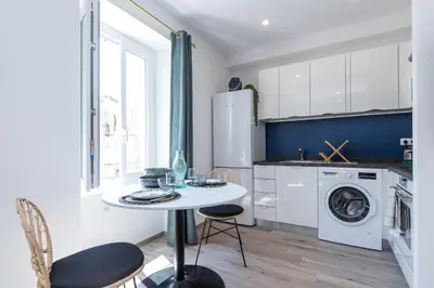 a kitchen with a table and a washing machine at Lovely Apartment City Center Heart - AC in Nice
