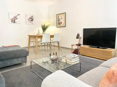 a living room with a couch and a tv and a table at Cozy 2BR Appartment near the Port of Nice in Nice