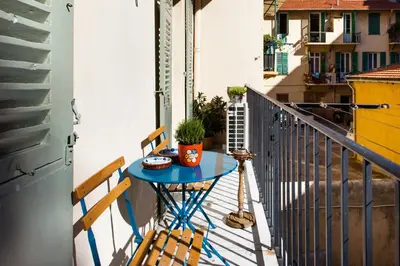 a small blue table on a balcony with two chairs at Cozy 2BR Appartment near the Port of Nice in Nice