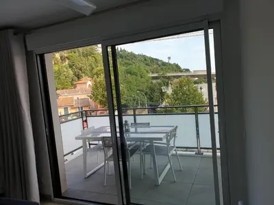 a balcony with a table and a view of the water at COTE VILLAGE in Nice