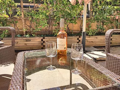 a bottle of wine and two wine glasses on a table at Nestor&Jeeves - HOLIDAY VIBES - Very close sea - Free parking in Nice