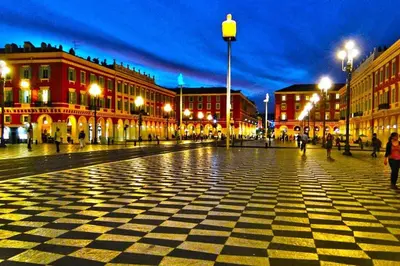 a city street at night with people walking around at Bienvenue sur la Cote d'Azur in Nice