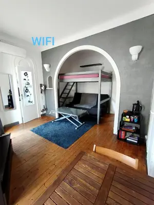 a living room with a bed and an archway at Charmant studio climatisé centre Villefranche sur mer in Villefranche-sur-Mer