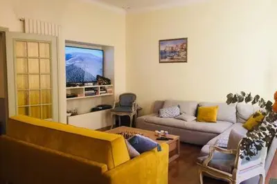 a living room with a couch and a tv at Le GIULIANO in Nice