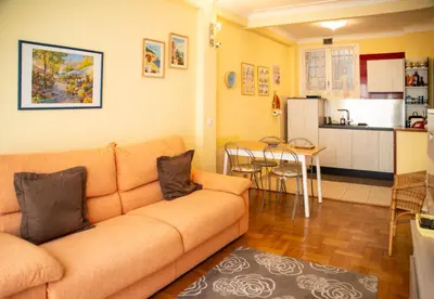 a living room with a couch and a kitchen at Joli 2 pièces climatisé à 150m de la plage in Nice