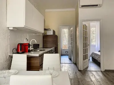 a kitchen with white cabinets and white tables and chairs at 2-bedrooms аpartment Nice Port with parking in Nice