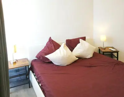 a bedroom with a bed with four pillows on it at 2-bedrooms аpartment Nice Port with parking in Nice