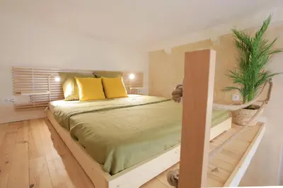 a bedroom with a bed with yellow pillows and a plant at Charmant Studio climatisé - Vieux Nice in Nice