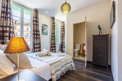 a small bedroom with a bed and a lamp at MY CASA - GUISOL - Typical Nice 3 Bedroom AC near Port in Nice