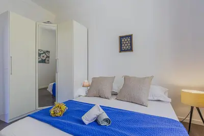 a bedroom with a bed with blue sheets and a mirror at MY CASA - GUISOL - Typical Nice 3 Bedroom AC near Port in Nice
