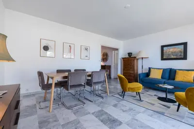 a living room with a table and chairs and a blue couch at Sea View Park Swimming Pool & Tennis 2 Bdrs in Villefranche-sur-Mer