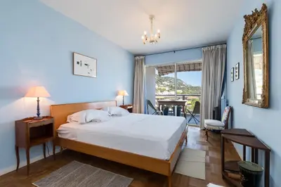 a bedroom with a bed and a mirror and a table at Sea View Park Swimming Pool & Tennis 2 Bdrs in Villefranche-sur-Mer