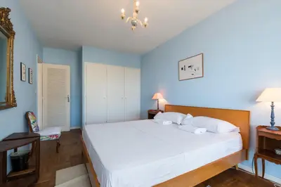 a bedroom with a large white bed and blue walls at Sea View Park Swimming Pool & Tennis 2 Bdrs in Villefranche-sur-Mer