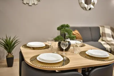 a wooden table with plates and wine glasses on it at Home Inn - Centre ville - Nice in Nice