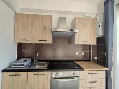 a kitchen with wooden cabinets and a sink at L'Ambre d'Or in Falicon