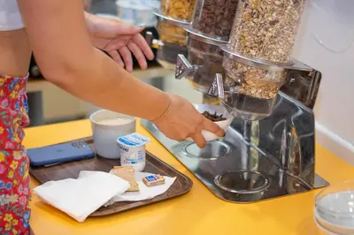 a person is preparing food in a blender at Auberge de Jeunesse HI Nice Les Camélias in Nice