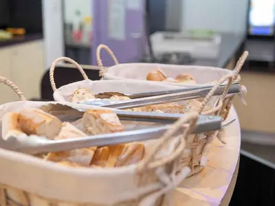 two baskets of pastries on a table with tongs at Auberge de Jeunesse HI Nice Les Camélias in Nice