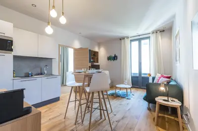 a kitchen and living room with a table and chairs at Refined & Cozy 1 Bedroom Downtown in Nice