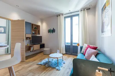 a living room with a couch and a table at Refined & Cozy 1 Bedroom Downtown in Nice