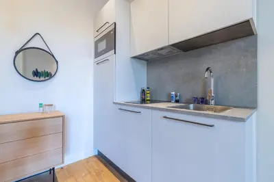 a kitchen with a sink and a mirror at Refined & Cozy 1 Bedroom Downtown in Nice