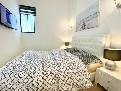 a white bedroom with a bed and a window at LAMARTINE- Heart of Center- Modern and Design flat in Nice