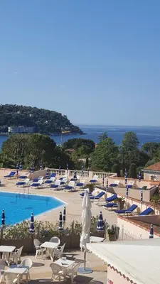 a resort with a pool and chairs and a statue at Appartement Ange Gardien Vue Mer in Villefranche-sur-Mer