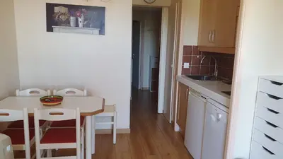 a small kitchen with a table and a table and chairs at Appartement Ange Gardien Vue Mer in Villefranche-sur-Mer