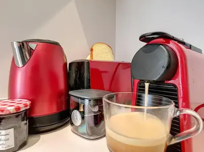 a cup of coffee is sitting next to a toaster at Silver Beach Central 4pers Séjour 30jours Location éligible au Bail Mobilité Mobility Lease in Nice