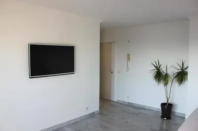 a living room with a tv on a white wall at Azur 3000 in Saint-Laurent-du-Var