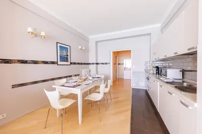 a kitchen and dining room with a white table and chairs at Wonderful Apartment on Sea in Nice