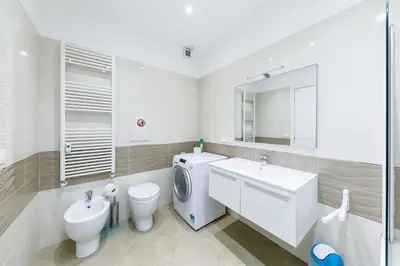 a white bathroom with a washing machine and a sink at Wonderful Apartment on Sea in Nice
