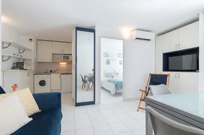 a living room with a blue couch and a kitchen at Comfortable 1 Bdr Downtown - AC & Parking in Nice