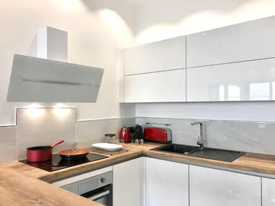 a kitchen with white cabinets and a stove top oven at Sea view - Promenade des Anglais in Nice