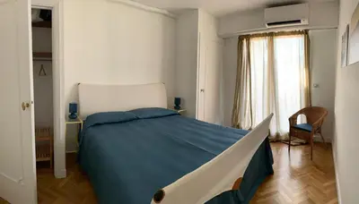 a bedroom with a large bed with a blue blanket at Appartement Front de Mer - Promenade des Anglais in Nice