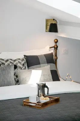 a bedroom with a white bed with a tray on it at COCOON LOFT - MAGNIFIQUE LOFT SOUS TOIT, REFAIT A NEUF, VUES SPLENDIDES, CLIM, WIFi in Nice