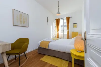 a bedroom with a bed and a desk and a chair at MY CASA - GIOFFREDO 14 - Spacious apartment with balcony in Nice